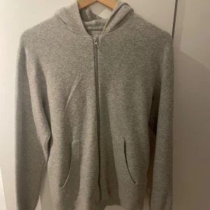 Grå hoodie från Jack & Jones Core - Grå hoodie från Jack & Jones Core i storlek S. Tröjan har huva, hel dragkedja framtill och två fickor. Mjuk och skön bomullsmix, perfekt för chill eller häng. Klassisk passform med långa ärmar och ribbade muddar. Hoodien är knappt använd och väldigt skön att använda under en höstlig dag. ABS! Pris går att diskutera!!!