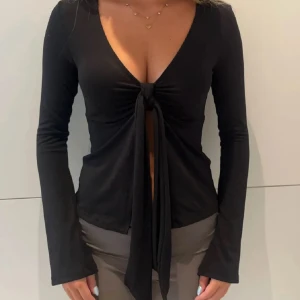 Topp från Ginatricot  - Säljer denna svarta knyttopp från Ginatricot i fint skick. Strl Xs. Något genomskinlig