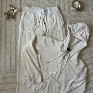 Beige hoodie med dragkedja och huva - Mysig beige hoodie med dragkedja och huva, samt snörning i halsen. Tröjan har långa ärmar, ribbade muddar och praktiska fickor framtill. Perfekt för en avslappnad stil och passar bra till matchande byxor.