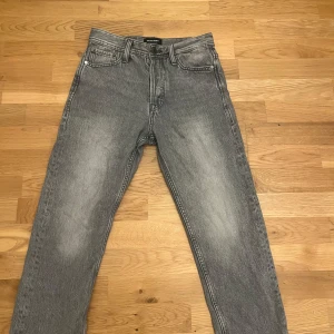 Gråa relaxed jeans Jack & Jones - Säljer ett par gråa jeans från Jack & Jones i modellen Relaxed Chris. Jeansen har en avslappnad passform, klassisk femficksdesign och snyggt tvättad look. Perfekta för dig som gillar en loose och bekväm stil.
