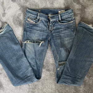 Blå slitna jeans från Diesel - Snygga blå jeans från Diesel med slitna detaljer och revor på benen, passar till allt!