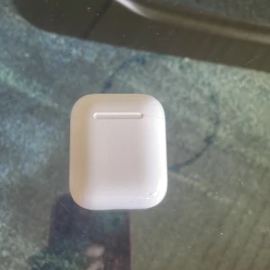 AirPods (2nd generation) - Apple AirPods (2nd gen) med laddningsetui. Fungerar, men synligt smutsiga och med tecken på användning. Medföljer även ett svart marmormönstrat skyddsfodral. Funkar utmärkt, kan mötas upp i hela Göteborg 