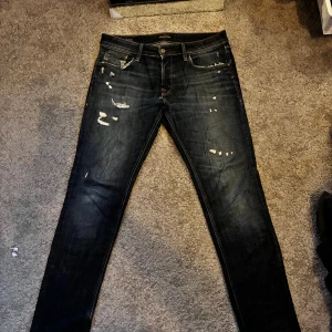 Mörkblå slim jeans med slitningar och fade - Snygga mörkblå jeans med slim fit och slitna detaljer framtill. Klassisk femficksmodell med dragkedja och knapp. Jeansen har en cool tvätt och slitningar som ger en trendig look. Perfekta för dig som gillar en smal siluett och streetstyle. Perfekt nu för hösten!💥🍁🍁 FUNKAR PERFEKT MED BÄLTE. SITTER MINDRE I WAISTEN UNGEFÄR 