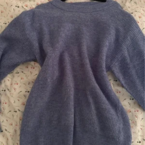 Ljusblå stickad tröja - Supermysig ljusblå stickad tröja med rund hals och långa ärmar. Perfekt för kyliga dagar och enkel att matcha med jeans eller kjol. Tröjan har en ribbad struktur som ger en snygg och avslappnad look.