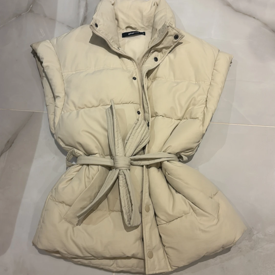 Beige quiltad dunväst med bälte - 1