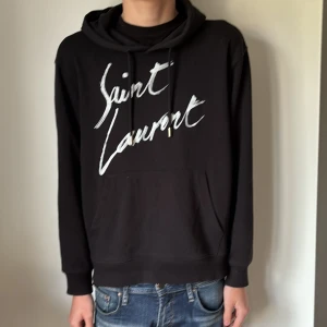 Svart Saint Laurent hoodie  - Säljer denna Saint Laurent hoodien i storlek S då den inte kommer till användning speciellt mycket. Mycket bra skicka med 0 defekter. Hör av dig vid minsta fundering 