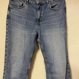 Blå raka jeans straight fit - Klassiska blå jeans med rak passform och fem fickor. Jeansen har en snygg tvättad look och är tillverkade i slitstarkt denim. Perfekta för dig som gillar en enkel och tidlös stil. Midjan är low waist och benen är raka hela vägen ner.
