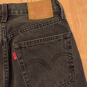 Levi's 501 svarta jeans - Svarta Levi's 501 jeans med klassisk rak passform och femficksdesign. Jeansen har hög midja, knappgylf och tydliga Levi's-detaljer som läderpatch och röd etikett på bakfickan. Tillverkade i robust denim som ger en tidlös look. Har ett par mörkgrå, ett par ljusgrå och ett par ljusblå. Samma storlek modell och skick. 350:- st eller 800:- för alla tre. 