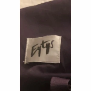 Bruna sneakers från Eytys i mocka - Säljer ett par bruna sneakers från Eytys med ovandel i mocka och klassisk vit sula. Skorna har rund tå, snörning och en stilren design som passar perfekt till streetwear. Tydlig Eytys-logga på insidan och bakre hälflik i matchande färg.