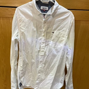Vit skjorta från Hilfiger Denim - Klassisk vit skjorta från Hilfiger Denim. Skjortan har lång ärm, bröstficka med liten broderad logga och knäppning framtill. 