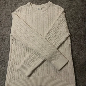 Helt ny vit kabelstickad tröja - Säljer en vit kabelstickad tröja från Kappahl i storlek 158/164 ‼️skulle säga att den är mer XS än 158/164‼️. Tröjan har rund halsringning, långa ärmar och breda ribbade muddar. Perfekt för dig som gillar klassisk och stilren look med mysig känsla.