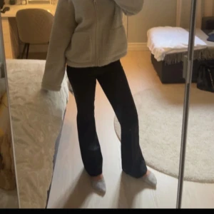Svarta bootcut kostymbyxor - Säljer ett par svarta kostymbyxor i bootcut-modell i mid waist. Byxorna har klassisk dragkedja och knapp framtill. Snygg passform som sitter tajt upptill och släpper ut vid bensluten.