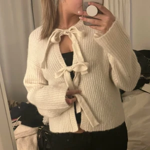 Kofta med knyt - Superfin vit ribbad kofta med två stora knyt framtill 😇 Koftan har långärmade och lite loose passform, perfekt att slänga över en topp 🥰 