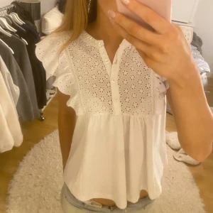 Vit topp Mango - Superfin vit topp från Mango! Den har volangärmar och broderade detaljer i fram. Inte använt så mycket så skicket är mycket bra!