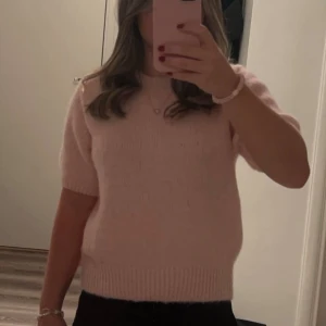 Ljusrosa stickad tröja med kort ärm - Superfin ljusrosa stickad tröja med korta ärmar och ribbade kanter. Storlek M, men tröjan är liten i storleken så passar dig som vanligtvis bär storlek XS. Endast använd få gånger så i bra skick🩷
