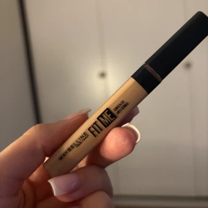 Maybelline Fit Me Concealer - Fit Me Concealer från Maybelline i en ljus beige nyans. Kommer i en smidig tub med svart lock och applikator för enkel applicering. Perfekt för att täcka mörka ringar  och ojämnheter. Passar dig som vill ha en naturlig finish. Knappt använd