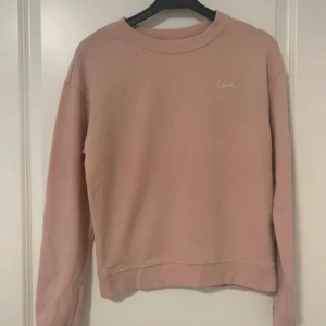 Rosa sweatshirt med broderad text - Rosa sweatshirt med liten broderad text 'love' på bröstet