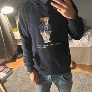 Mörkblå Polo Bear hoodie från Ralph Lauren - Säljer en riktigt snygg och skön raffe hoodie. Hoodie sitter riktigt bra och är riktigt fräsch. Storlek M men passar även S. Hör av er vid frågor