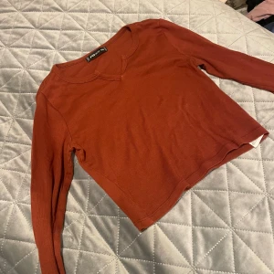 Rostbrun långärmad tröja FB Sister - Snygg rostbrun långärmad tröja från FB Sister i storlek XXS. Tröjan har en enkel design med rundad hals och är tillverkad i mjuk bomull. Perfekt för dig som gillar basic och vill ha en chill vibe i garderoben.