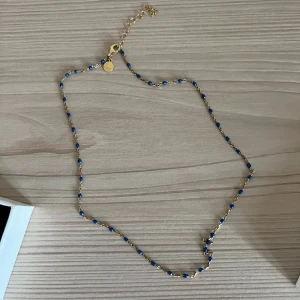 Halsband - Guld halsband med blå pärlor, vet ej vart det är ifrån🩷