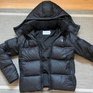 Svart jacka från Calvin Klein - En snygg och sparsamt använd Calvin Klein jacka i fint skick! Köpt från Zalando, storlek xs. En bra jacka som värmer och ser bra ut!🙌