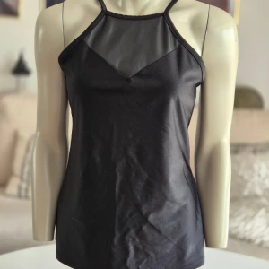 Even&Odd * svart linne * stl M - Svart Even&Odd Active linne med en unik design.  Framtagen för träning men snygg till vad som helst. * Halterneck-stil med smala band som går över axlarna och bildar ett läckert mönster på ryggen.  * Framsidan har en detalj i fuskskinn som lyfter plagget snyggt! * Mycket bra skick. Hittar inga fel. * Stl M, normal i storleken.   Djur och rökfritt hem. Se bilder och förstora då de ingår i beskrivningen. Se gärna mina övriga annonser.  