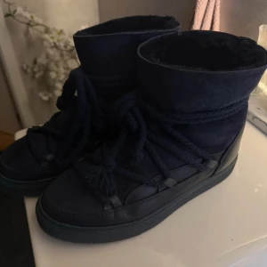 Svarta Inuikii boots i mocka och skinn - Säljer dessa marinblå Inuikii boots med högt skaft, snörning och platt sula. Skorna är tillverkade i en mix av mocka och skinn, med grova snören som ger en cool look. Jättefint skick! 