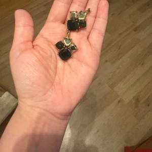 DYRBERG/KERN Guldiga örhängen  - Snygga Unika DYRBERG/KERN örhängen i guldton med stora gröna, gula och olivfärgade stenar i olika former. Stenarna är facetterade och infattade i guldfärgad metall, vilket ger ett lyxigt och färgstarkt intryck. Perfekta för dig som vill sticka ut med accessoarer.