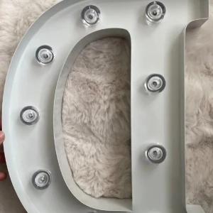 Bokstavslampa LED D - Säljer en vit dekorativ bokstavslampa i form av bokstaven D. Lampan är tillverkad i plast och har små LED-lampor runtom. Den drivs av batterier och har en av/på-knapp på sidan. Med batterier 35 kr utan 25 kr 