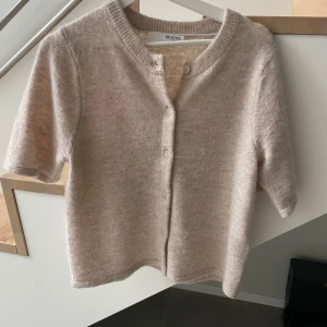 Beige kortärmad kofta från Selected Femme - Supermysig beige kofta från Selected Femme i storlek XS. Den är stickad med korta ärmar, rund hals och knappar framtill. Endast använts 2 gånger. Nypris 699