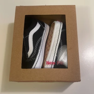 Babyskor Vans Old Skool Crib svart/vit sneakers - Säljer ett par nya Vans Old Skool Crib sneakers i klassisk svart och vit färg med ikonisk sidorand och kontrastsydda detaljer. Skorna har platt sula och rund tå, tillverkade i textil och syntet med röd Vans-logga på hälen. Perfekt för små barn som vill ha streetstyle från start.  Har fått två par exakt likadana, säljer ena paret. Stl 3-6 månader.