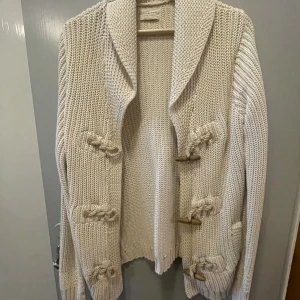 Beige stickad kofta från Ralph Lauren - Säljer en chunky beige stickad kofta från Denim & Supply Ralph Lauren. Koftan har stora träknappar, bred krage och grovstickad struktur. Perfekt för lager-på-lager och chill höst- eller vinterstil. OPS! pris går att diskutera 