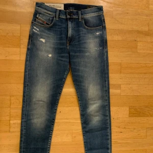 Blå Diesel jeans, storlek 29 - Snygga blå jeans från Diesel med slitna detaljer och klassisk femficksdesign. Jeansen har en smal passform och är tillverkade i stretchig denim av 98% bomull och 2% elastan. Perfekta för dig som gillar en modern och avslappnad look.