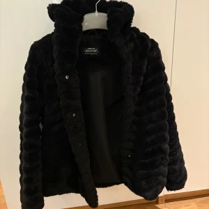 Svart pälsjacka  - Mysig svart pälsjacka från Hailys med huva och knäppning framtill.🖤