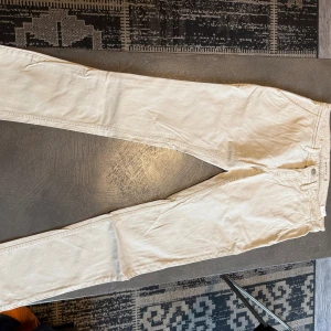 Beige jeans från Siviglia Denim, stl 33 - Snygga beige jeans från Siviglia Denim i storlek 33. Modellen har klassisk femficksdesign, raka ben och knappstängning fram. Materialet är mjukt och skönt bomullstyg som ger en clean och fräsch look. Perfekt för dig som gillar stilrena och ljusa jeans.