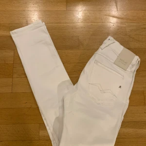 Vita Replay Anbass slim jeans, stl 28 - Snygga vita Replay Anbass Hyperflex jeans i slim fit med klassisk femficksdesign och diskreta sömmar. Stretchigt material som sitter tajt och bekvämt. Perfekta för dig som gillar stilrena och fräscha jeans med modern passform.