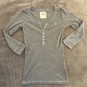 Trekvartsärmad topp Hollister knappar 2000-tal - Supersnygg grå hollister topp som är trekvartsärmad i storlek S. Bra skick.❤️
