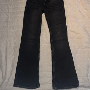 Svarta bootcut jeans från H&M - Säljer ett par svarta/mörkgråa jeans från H&M. De är aldrig använda, bara testat de. Basic fickor baktill, du knäpper de där fram med dragkedja och en knapp. Priset kan diskuteras.