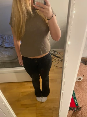 Brun ribbad croppad t-shirt - Säljer en brun croppad t-shirt med ribbad struktur och korta ärmar. Toppen har en enkel och stilren design med rund hals och är perfekt för dig som gillar en chill och avslappnad look. Passar dig som vill ha en basic topp med lite edge.