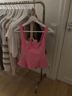 Rosa linnetopp med rosett från Zara - Adrig använd!! Säljer en superfin rosa linnetopp från Zara i storlek S. Toppen har breda axelband, figurnära passform och en stor rosett framtill som ger en extra söt touch. Materialet är mjukt och lätt polyester, perfekt för vår och sommar. Passar dig som gillar färg och statement-detaljer.🩷🩷🩷
