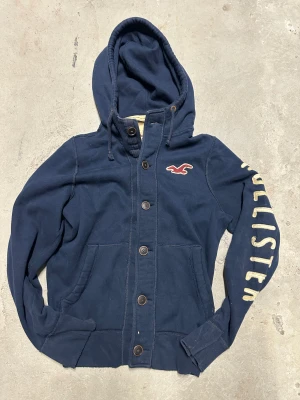 Vintage Hollister kofta med knappar - Extremt eftertraktad och sällsynt vintage  Hollister hoodie med knappar! Grymt skick, inga defekter - ser exakt ut som på bild! Storlek M. Skriv vid frågor!💬