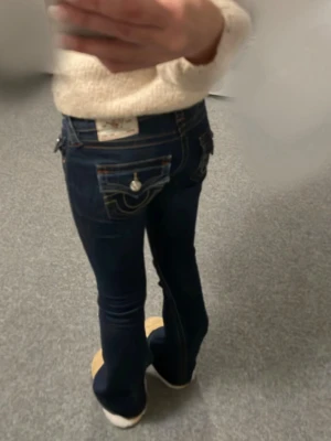 True religion jeans mörkblå  - Säljer mina lågmidjade true religion jeans, färg mörkblå. Egentligen storlek 24/32 men de är uppsydda så de är nu storlek 24/30. Innerbenlängd 77 cm, midjan runt om 80 cm, midjan rakt över 36 cm. De är använda fåtal gånger,  är fortfarande i bra skick. Säljer för 700kr. Köpte för 1300kr