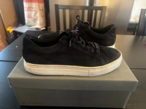 Vagabonds Marinblåa - Säljer ett par stilrena mörkblåa sneakers från Vagabond i mjuk mocka. Skorna har klassisk snörning, vit platt sula och rund tå. Perfekta för dig som gillar minimalistisk och clean stil. Passar till det mesta och är riktigt bekväma.