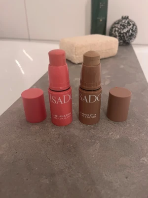 Isadora blush och contour stick duo - Två smidiga stick från Isadora: ett blush stick i färgen 62 Rose Perfection, en fräsch rosa ton för kinder, läppar och ögon, samt ett contour stick i färgen 32 Beige Neutral, perfekt för att skulptera och definiera ansiktet. Praktiska stift i plastförpackning. Båda för 59