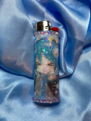 HATSUNE MIKU - lighter - ⭐️1st Refillable BIC MAXI LIGHTER med wrap & rhinestones ⭐️ ✨OBS: under lighter drop 13/12 kommer endast de lighters som har foto och eller sticker med sig i bilden inkludera det, de lighters som ej har något mer i bilden kommer utan något extra!✨🤍 FREEBIES (godis & random stickers) ingår alltid i alla paket 🤍
