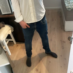 Mörkblå jeans från Scotch & Soda - Säljer ett par mörkblå jeansbyxor med klassisk femficksdesign och normal passform. Byxorna har dragkedja och knapp framtill samt raka ben. Perfekta till vardags och passar till det mesta. Passar längden 165-170 