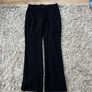 Svarta kostymbyxor från Lindex, stl 158 - Svarta kostymbyxor från Lindex i storlek 158. Det är raka/bootcut ben och har även hällor för bälte. Fickor framtill och bakfickor som inte har utrymme. Stängs med dragkedja, knapp och hake, de är i väldigt fint skick och är använda ca 3-4 gånger men ser ut som nya. Köpta för 349 kr. Hör gärna av er vid intresse eller funderingar!💞💞