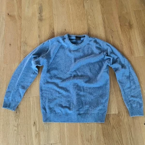 Oscar Jacobson stickad tröja - Stickad tröja från Oscar Jacobsson i ljusblå, knappt använd