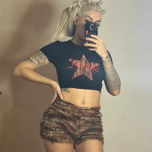 Bruna fluffiga stickade shorts med croptop - Supercoola stickade shorts i bruna och beige toner med fluffig textur. De har hög midja och en loose fit som ger en avslappnad vibe. Perfekta för dig som vill sticka ut med en unik och mysig stil. Crop top använts 1 gång. Shorts oanvända. 