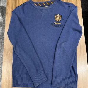 Morris stickad crewneck (oldmoney stuk) - Snygg blå stickad tröja från Morris med broderad logga och emblem på bröstet. Tröjan har rund hals, ribbade muddar och är långärmad. Perfekt för dig som gillar klassisk stil med en modern touch. (Oldmoney, äldre modell) Mycket fint skick! Nypris ca 1800kr, säljer för 475kr! Allt gott, Brur!🫰🏽
